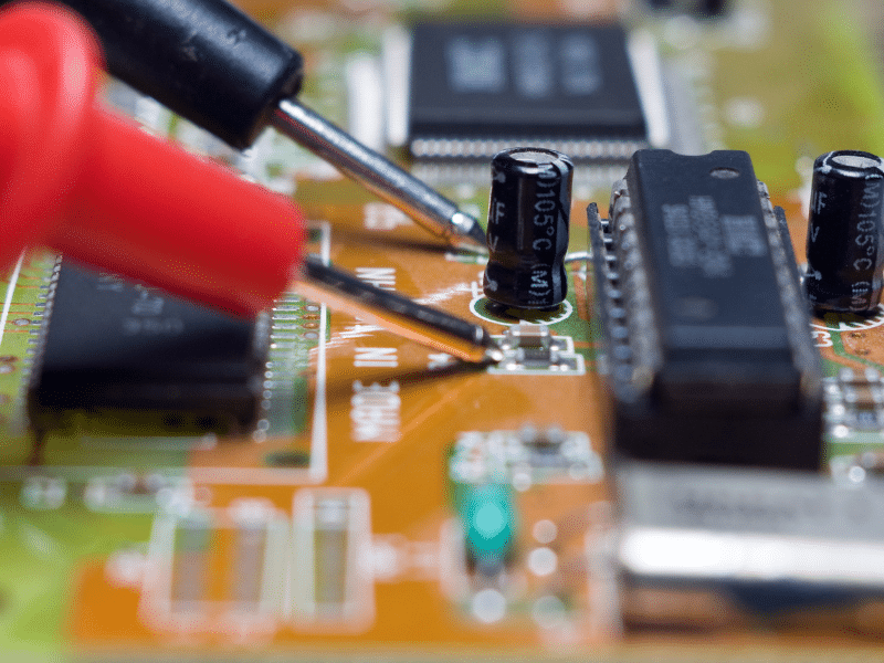 Soldering iron working on tiny electronic parts.