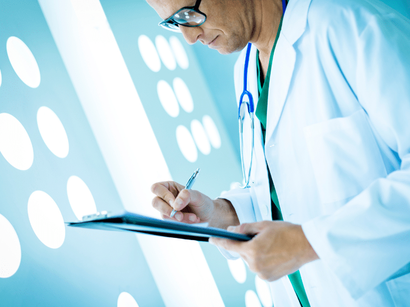 Doctor in a lab coat and stethoscope holding a clipboard.