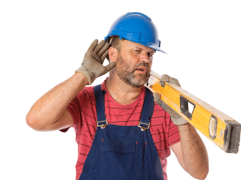 Construction worker wearing a hardhat and carrying a giant level.